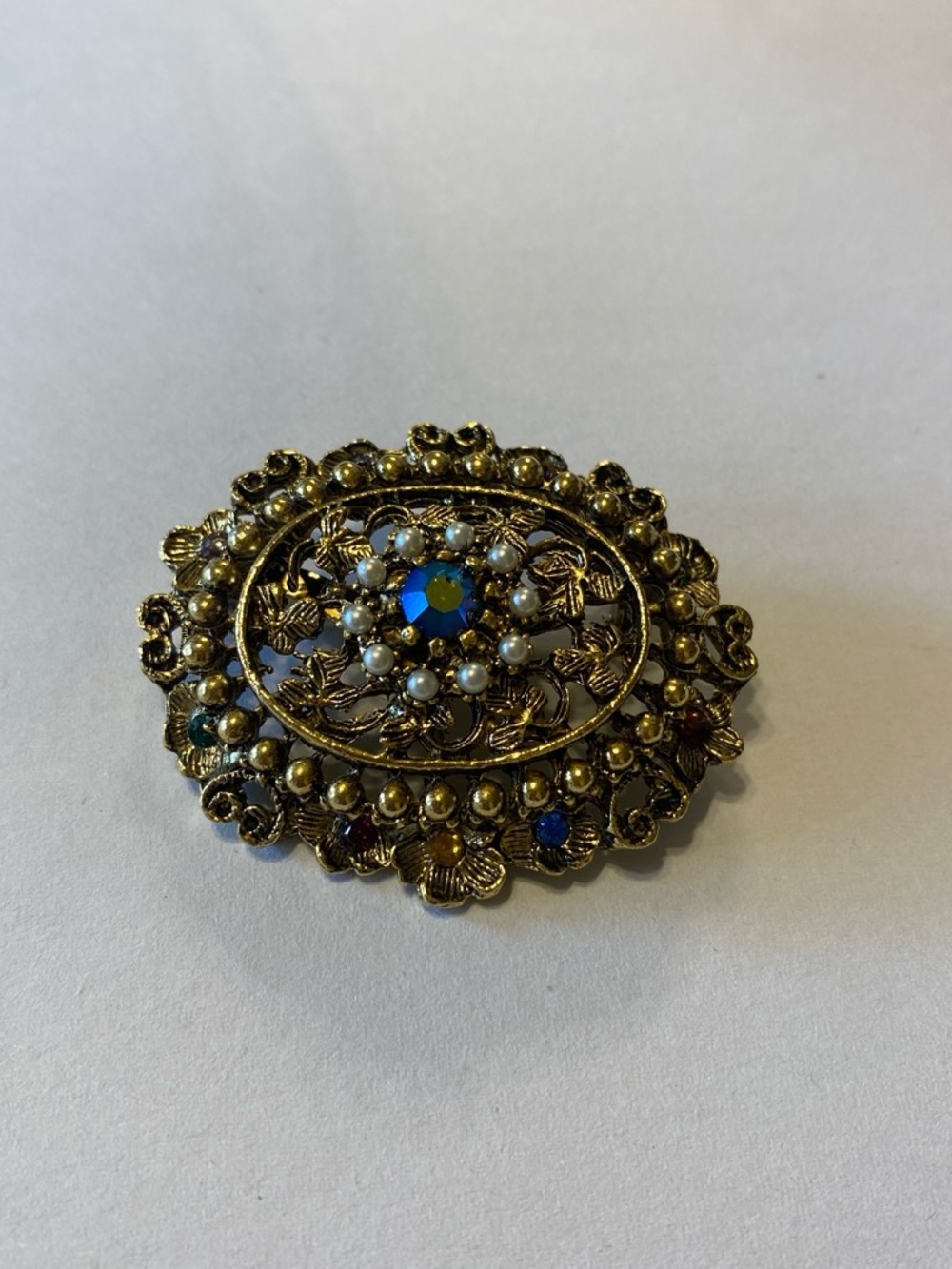 Vintage-Inspired Gold Floral Brooch with Blue Center Stone